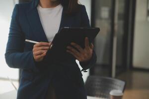 coup de une asiatique Jeune affaires femelle travail sur portable dans sa poste de travail. photo