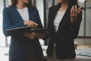 entrepreneur asiatique homme d'affaires et femme d'affaires discutant d'un nouveau projet d'entreprise dans une tablette lors d'une réunion moderne dans un bureau moderne, concept décontracté d'affaires asiatique. photo