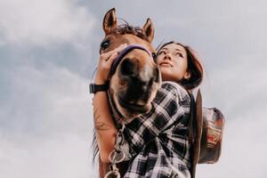 Jeune content femme avec sa cheval dans soir le coucher du soleil lumière. Extérieur la photographie avec mode modèle fille. mode de vie ambiance. oncept de Extérieur équitation, des sports et des loisirs. photo