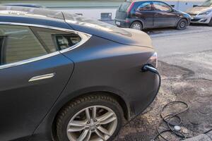 électrique moderne voiture mise en charge avec câble Puissance la fourniture branché sur station photo