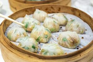 Ha gow légume rempli dans pâte feuille. faible somme chinois nourriture dans en bois plateau photo