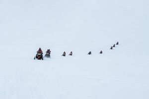 groupe de touristes équitation motoneiges sur neigeux glacier Montagne photo