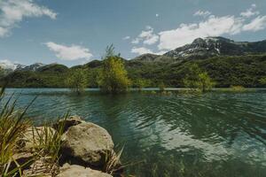 paysage de une Lac entouré par montagnes photo