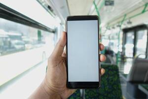 passager séance dans une autobus en utilisant le sien téléphone. photo