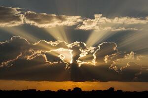 ai généré sunlights radiant des rayons filtre par spectaculaire nuage formations photo