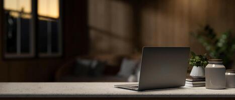 une portable ordinateur sur une bureau dans une contemporain vivant pièce dans le soir. endroit de travail concept photo