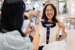 une femme prise une image de sa ami avec une Nouveau vêtir, ayant une amusement achats journée ensemble. photo