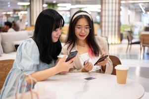 deux content Jeune asiatique femelle copains sont pendaison en dehors ensemble à le achats centre commercial sur le fin de semaine. photo