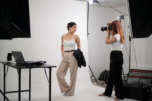 une professionnel photographe est prise des photos de un attrayant Jeune asiatique femelle modèle dans une studio