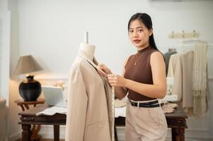 une professionnel asiatique femelle tailleur est travail dans sa studio, mesure tailles avec une mesure enregistrer. photo