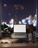 une portable ordinateur maquette sur une ordinateur supporter sur une bureau contre le fenêtre avec une nuit ville voir. photo