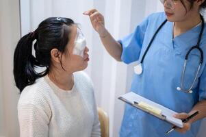 une médecin ou ophtalmologiste est vérification une les patients œil dans le examen pièce à le hôpital. photo