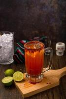 Michelada, typique mexicain cocktail sur une en bois tableau. Bière cocktail. photo