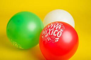 des ballons avec mexicain drapeau couleurs et texte viva Mexique sur Jaune Contexte. cinco de mayo de fête Contexte. photo