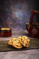 vanille Chocolat puce biscuits avec thé ensemble dans le Contexte sur en bois tableau. photo