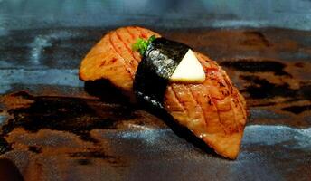 proche en haut Matsuzaka du boeuf Sushi avec tranché Ail sur Haut dans noir assiette avec copie espace. Japonais nourriture concept photo