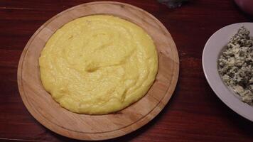 4k court vidéo de une assiette de très chaud crémeux polenta, une assiette de gorgonzola fromage et une assiette de noix photo