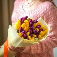 femme en portant Jaune et violet tulipe bouquet photo