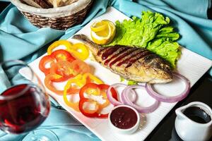 blanc assiette avec poisson et des légumes photo
