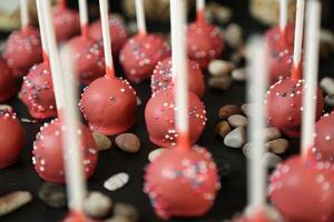 rouge gâteau pop avec arrose sur une noir assiette photo