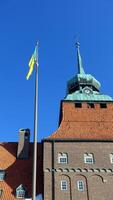 Östersund, Suède, Mars 13, 2022 le impressionnant historique ville salle bâtiment affichage le ukrainien drapeau. photo