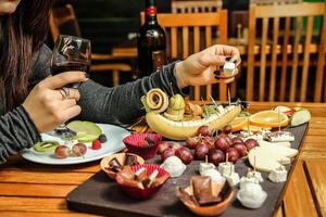 femme séance à table avec assiette de nourriture et verre de du vin photo