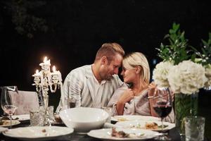 se regarder avec amour. un beau couple adulte prend un dîner de luxe le soir photo