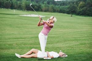 deux femmes décident de jouer au golf d'une autre manière. essayez ceci est à vos risques et périls photo
