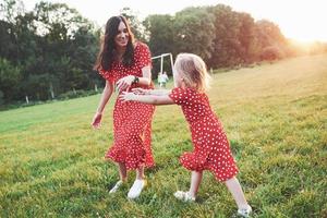 attrape-moi si tu peux. jeune mère avec sa fille passant du temps dehors dans un si bel endroit photo