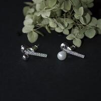 argent des boucles d'oreilles sur une noir Contexte avec fleur photo