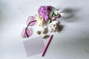 rose lunettes, pivoines et mer coquilles sur une blanc en bois tableau. romantique été plat poser. photo