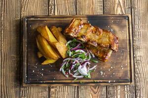 frit patates avec grillé Viande sur une en bois tableau. photo