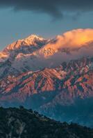 couvert de neige Montagne en dessous de nuageux ciel photo