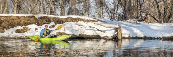 pagayer gonflable eau vive kayak sur une rivière dans hiver photo