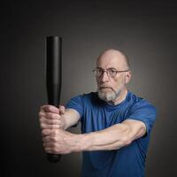 Sénior homme est exercice avec une acier club photo