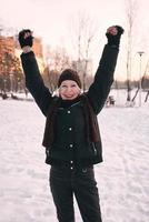 femme âgée au chapeau et veste sportive faisant des exercices sportifs dans le parc d'hiver de neige. hiver, âge, sport, activité, concept de saison photo