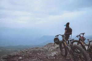 les hommes asiatiques voyagent dans la nature. voyage détendez-vous faire du vélo dans la nature sauvage. tenez-vous sur la ligne. dans la prairie dans les bois. Thaïlande photo