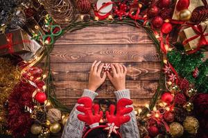 fille portant une composition plate de noël sur le fond en bois avec un espace de copie pour votre texte. joyeux Noel et bonne année. photo