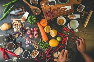 aliments sains herbes épices à utiliser comme ingrédients de cuisine sur un fond en bois avec des légumes biologiques frais sur bois. cuisiner. photo