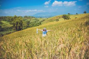 les femmes asiatiques voyagent se détendent pendant les vacances. étendre le champ de montagne de la carte d'enquête. culture de riz ranch sur la colline. Thaïlande photo