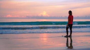 fille en cours d'exécution d'entraînement jogging sur la plage le matin. détendez-vous et heureux de courir sur la mer. en été photo