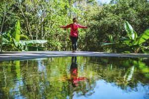 corps relaxant debout, exercice de yoga. sources chaudes dans le parc national, voyages dans la nature aux sources chaudes, détendez-vous et faites de l'exercice à la piscine. photo