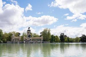 lac au parc du retiro, madrid, par une journée ensoleillée. bateaux et personnes au loin photo