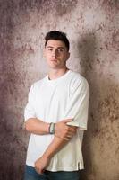 portrait d'un jeune homme séduisant avec un t-shirt blanc et un jean. photo