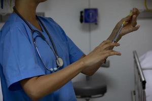 médecin tenant une seringue dans une chambre d'hôpital.