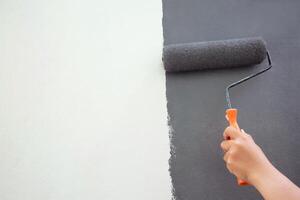 rouleau brosse peinture, ouvrier La peinture sur surface mur La peinture appartement, rénover avec gris Couleur peindre. laisser vide copie espace blanc à écrire descriptif texte à côté de. photo