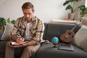 portrait de homme, touristique fait du des plans pour le sien suivant vacances, l'écriture une liste de des choses à prendre avec lui, fabrication une liste de contrôle photo