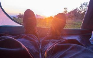 homme camping attendant de regarder le coucher du soleil photo