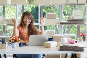 femme d'affaires porte décontractée vêtements séance sur une chaise dans le bureau. le travail bureau pour un entrepreneur dans le Bureau a une ordinateur portable, code à barre lecteur, et plus. espace pour texte. concept de affaires photo