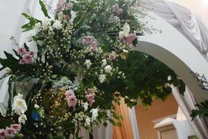 décoratif fleurs arrangé à le entrée à une mariage événement. photo